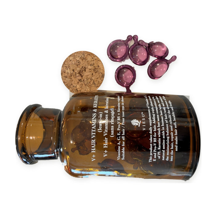 Vieso V+ Hair Vitamins & Keratin, amber glass jar on its side with the cork off and five purple twist-off leave-in hair capsules spilling out.